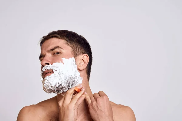 Snygg man med vitt raklödder i ansiktet och ren hud med rakhyvel grooming bara axlar — Stockfoto