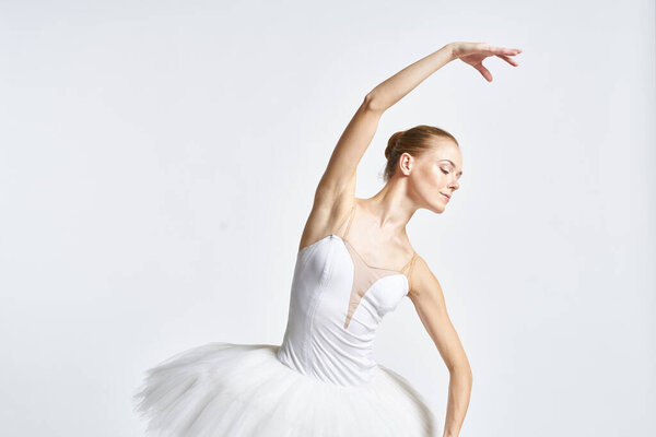 Woman ballerina in a tutu on a light background posing. High quality photo
