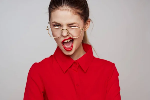 밝은 배경의 재미있는 감정을 가진 빨간 셔츠를 입고 있는 유행하는 여성밝은 화장 안경 매력적 인 외모 — 스톡 사진