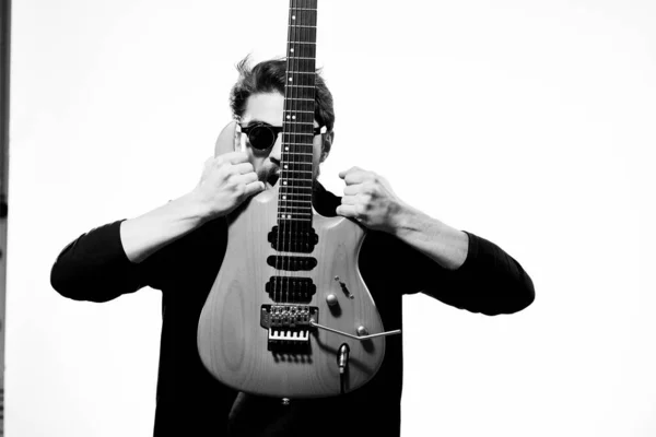 A man with a guitar emotions muzyka gry wydajność skóra kurtka okulary światło tło — Zdjęcie stockowe