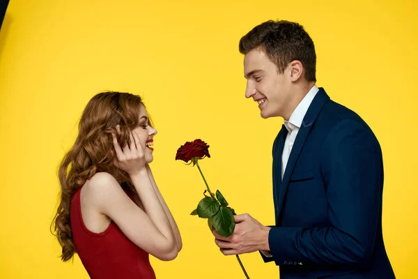情侣们，手握红玫瑰，拥抱着一个黄色背景的爱情家庭 — 图库照片