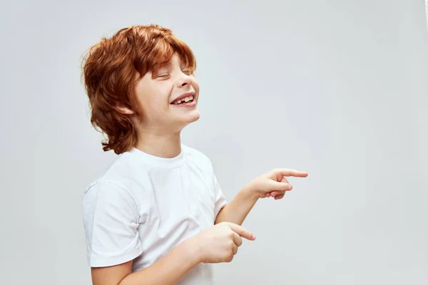 Sorridente ruiva menino cortado fundo gestos com as mãos cinza fundo emoções — Fotografia de Stock