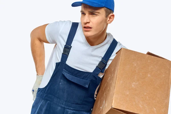 Hombre trabajador con caja en manos entrega servicio trabajo luz fondo — Foto de Stock