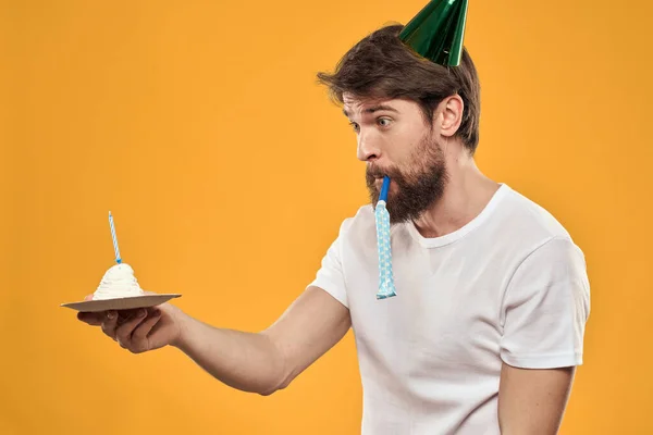 Hombre guapo con barba y gorra celebrando una fiesta de cumpleaños fondo amarillo — Foto de Stock