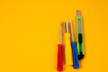 Onarım endüstrisi için sarı arkaplan donanımı üzerindeki tornavidalar ve inşaat araçları