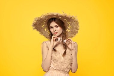 Şapkalı ve elbiseli bir bayan. Kızıl saçlı, sarı arka planlı, model portresi eğlenceli.