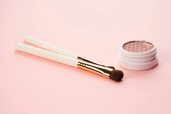 Makeup borstar och ögonskugga professionell kosmetika på rosa bakgrund — Stockfoto