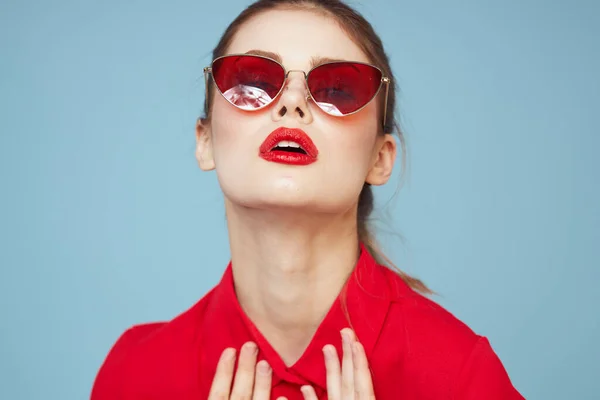 Piękna kobieta w ciemnych okularach jasny makijaż czerwone usta glamor niebieski tło — Zdjęcie stockowe