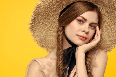 Sarı arka planda saman şapkalı portre kadın. Yazlık elbise mankeni romantizmi.