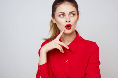 Açık arkaplanda kırmızı dudaklı bir kadının portresi. Makyaj modeli.