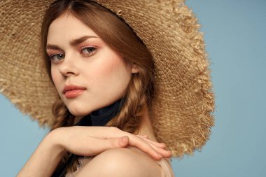 Hasır şapkalı kız portresi yakın çekim at kuyruğu eğlenceli kızıl saçlı mavi arka plan