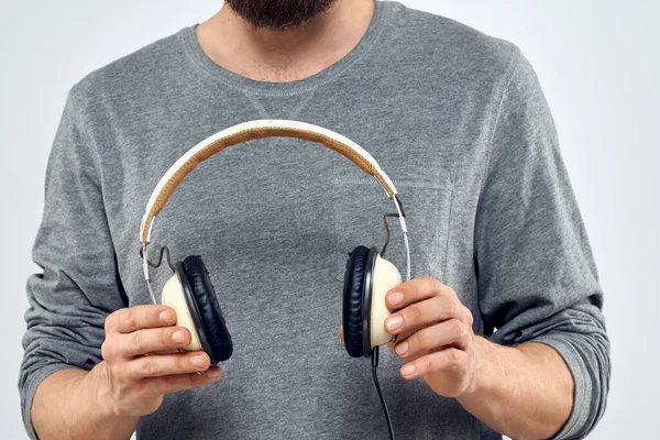 Mężczyzna trzyma słuchawki w rękach człowieka styl życia nowoczesny styl technologii przycięte widok — Zdjęcie stockowe