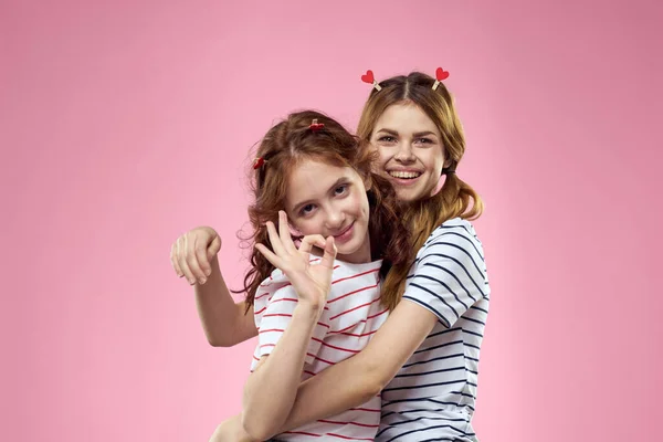 Vrolijke moeder en dochter vreugde lifestyle studio roze achtergrond familie — Stockfoto