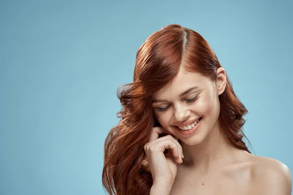 Schöne Frau lockiges langes Haar glatte Frisur nackte Schultern Kosmetik Pflege blauer Hintergrund — Stockfoto