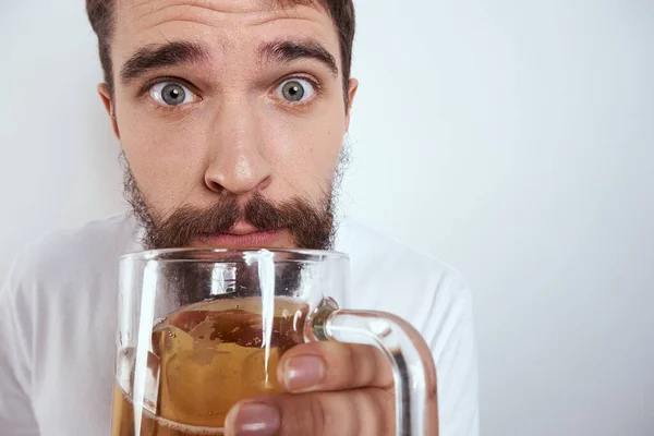 Büyük bir bardak birayla duygusal bir adam alkollü içki içiyor ve sarhoş halde el kol hareketi yapıyor. — Stok fotoğraf