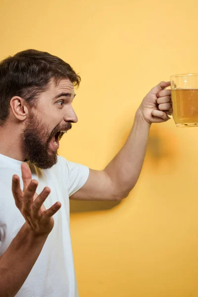 Homme avec une tasse de bière fun alcool style de vie blanc t-shirt jaune fond isolé — Photo