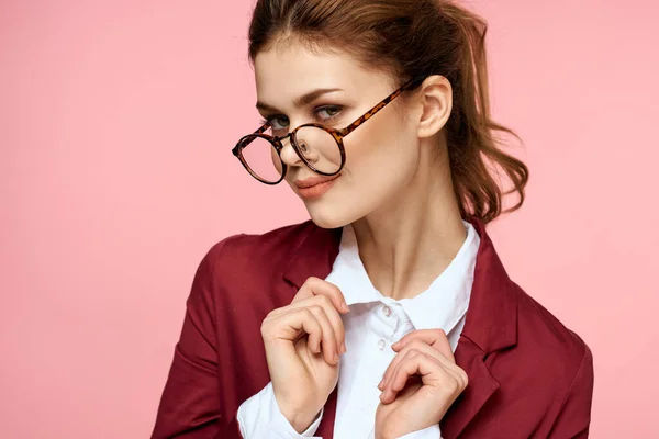 Elegant kvinna i röd jacka glasögon kontor manager rosa bakgrund — Stockfoto