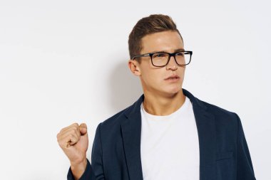 Ceketli, gözlüklü, menajeri kendine güveni olan, hafif bir iş adamı.