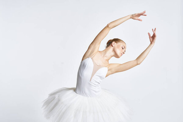 Woman ballerina in a tutu on a light background posing. High quality photo