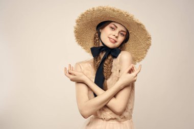 Şapkalı ve arka planda giyinmiş romantik bir kadın elleriyle komik duyguların portresini çiziyor.