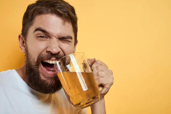 Homme avec une tasse de bière fun alcool style de vie blanc t-shirt jaune fond isolé — Photo