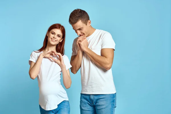 Zwangere vrouw in wit t-shirt en man getrouwd stel wachten op baby blauwe achtergrond bijgesneden weergave van emoties — Stockfoto