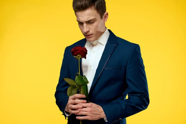 Gentleman i klassisk kostym på gul bakgrund med röd ros romantik — Stockfoto