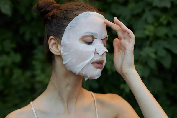 Mujer hermosa máscara antiarrugas Ojos cerrados y papel transparente cuidado de la piel hojas en el fondo —  Fotos de Stock