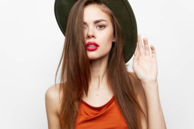 Şapkalı kadın, kafasındaki lüks saç modelinin yüzünü kapatıyor.