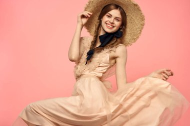 Şapkalı ve siyah kurdeleli güzel bir kadın. Pembe arka plan modeli.