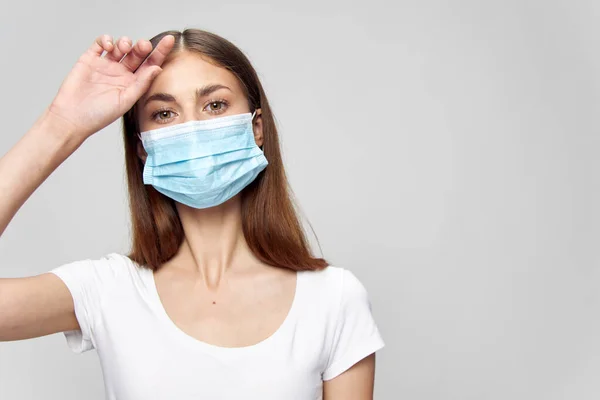 Flicka i medicinsk mask håller handen nära ansiktet och blickar framåt. — Stockfoto