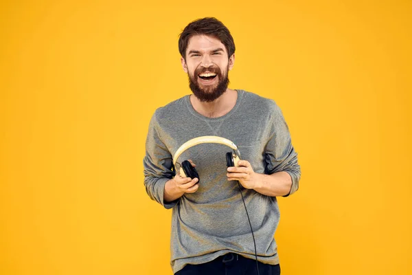 Людина в навушниках слухає музичні технології стиль життя веселі люди жовтий фон — стокове фото