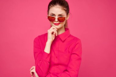 Pembe gömlekli ve kahverengi gözlüklü kadın kırpılmış görünüm modeli duyguları el hareketleriyle resim yapıyor.