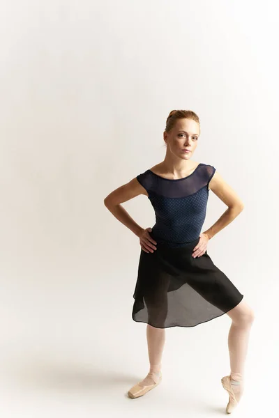 Bailarina em sapatos pontiagudos e em um tutu em uma dança de fundo leve posicionamento correto das pernas figura fina — Fotografia de Stock