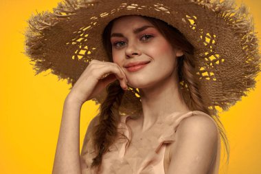 Şapkalı ve elbiseli bir bayan. Kızıl saçlı, sarı arka planlı, model portresi eğlenceli.