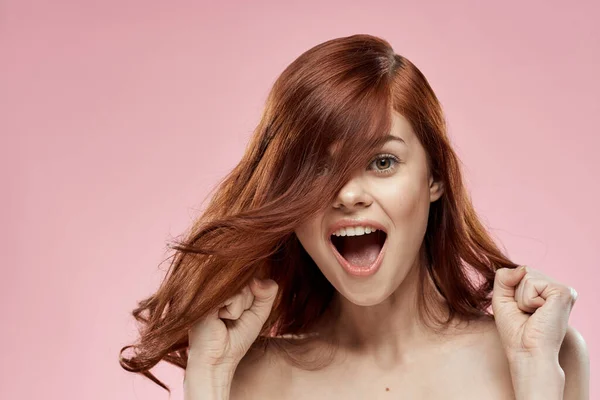 머리를 땋아 주는 아름다운 머리를 하고 있는 아리따운 여자 핑크 색 배경을 가진 미녀 — 스톡 사진