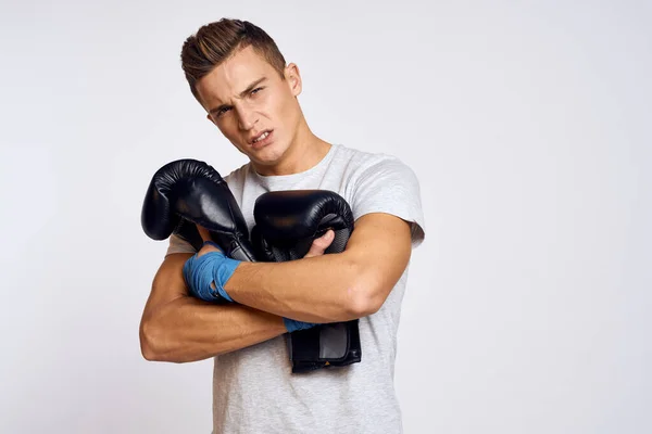 Uomo forte con guanti da boxe e in t-shirt bianca su sfondo isolato vista ritagliata del modello — Foto Stock