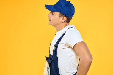 Çalışan üniformalı adam duygularını servis hizmeti sarı arka planda sunuyor