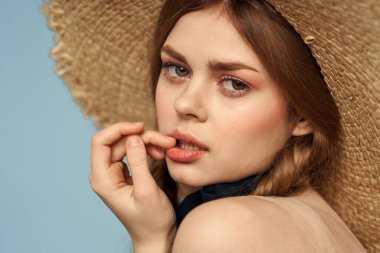 Hasır şapkalı kız portresi yakın çekim at kuyruğu eğlenceli kızıl saçlı mavi arka plan