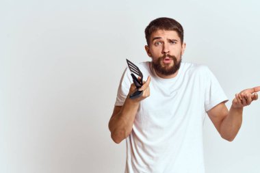 Beyaz tişörtlerinin elinde mutfak aletleri olan bir adam arka planda hafif bir görüntü oluşturdu.