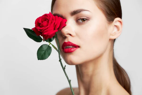 Nő hosszú gazdaság virág közel arc piros ajkak frizura tiszta bőr — Stock Fotó