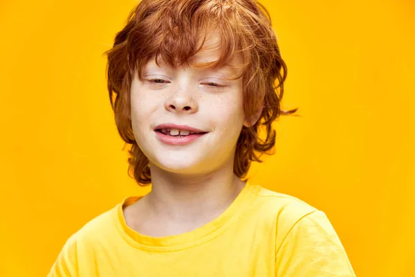 Glücklicher rothaariger Junge lacht mit geschlossenen Augen und gelbem T-Shirt — Stockfoto
