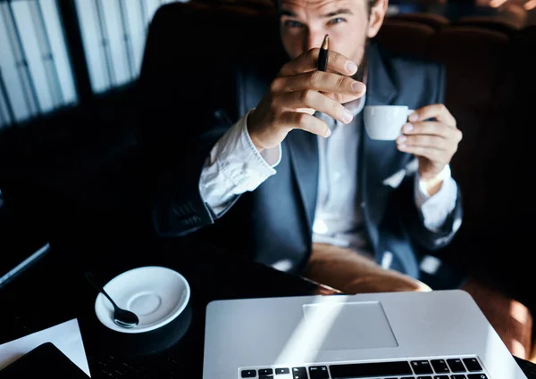 Uomo d'affari seduto in un caffè di fronte a un computer portatile con una tazza di caffè lavoro tecnologia stile di vita — Foto Stock