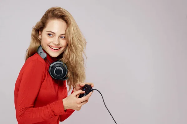 Femme avec contrôleur casque dans les mains un jeu de console amusant loisirs veste rouge style de vie arrière-plan léger — Photo