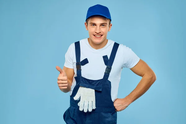 Working man in uniform of gloves loader rendering service blue background — Stock Photo, Image