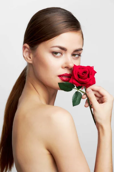 Donna con lunga Con una rosa vicino al viso per il rossetto acconciatura — Foto Stock