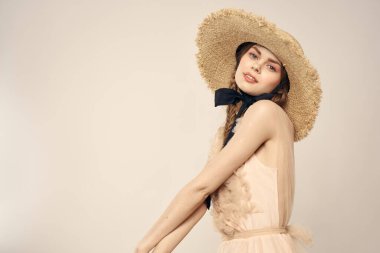 Şapkalı ve arka planda giyinmiş romantik bir kadın elleriyle komik duyguların portresini çiziyor.