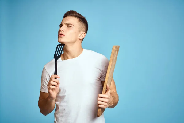 Cara enérgico com placa de cozinha de madeira e espátula emoções divertidas — Fotografia de Stock