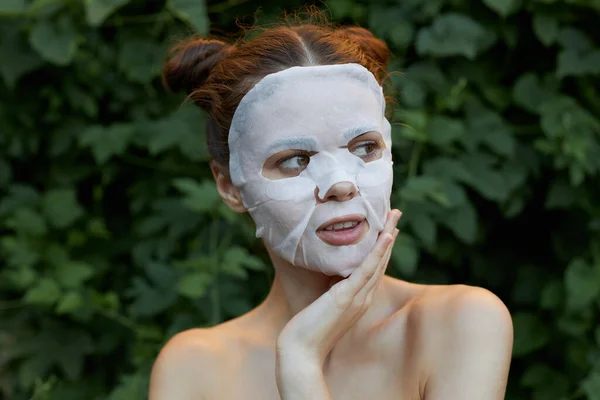 Nice perempuan masker wajah memegang tangannya di dekat wajahnya dan terlihat ke sisi kulit bersih — Stok Foto