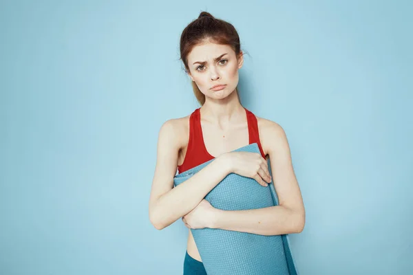 Sportliche Frau in roter Tank Top Matte für Trainingsübungen Lifestyle blauer Hintergrund — Stockfoto